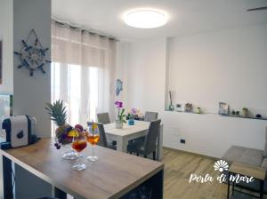 皮昂比诺Appartamento Perla di Mare的客厅配有桌子和两杯酒杯