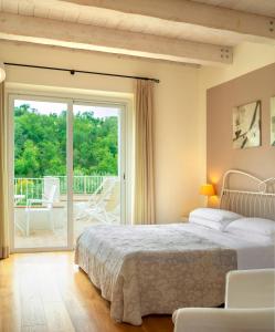努马纳Hotel Giardino Suites&Spa的一间卧室设有一张床和一个滑动玻璃门