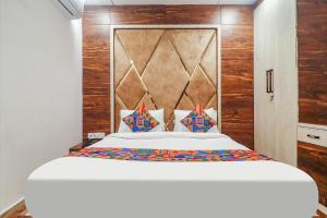 海得拉巴FabHotel Double Tree的卧室配有一张白色大床和木墙