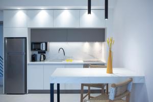 雷夫卡达镇Achillion Suites的厨房配有白色的桌子和冰箱。