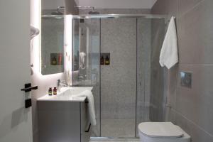 雷夫卡达镇Achillion Suites的带淋浴、卫生间和盥洗盆的浴室