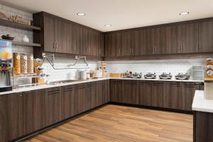 罗切斯特Residence Inn Rochester Mayo Clinic Area South的大型厨房设有木制橱柜和木地板。