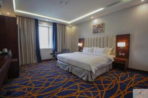 吉赞Quba Inn Hotel的配有一张床和一张书桌的酒店客房