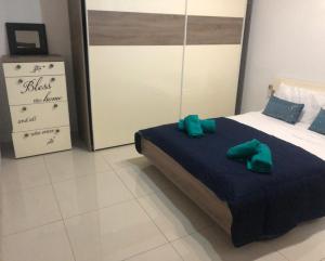 Is-SwieqiStanza vicino Paceville e San Giuliano的一间卧室配有一张带两个绿色枕头的床