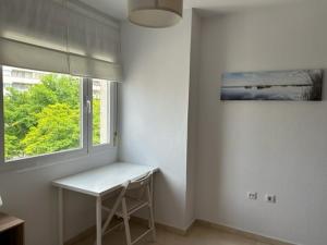圣费尔南多Apartamento en San Fernando centro的白色的客房设有桌子和窗户。