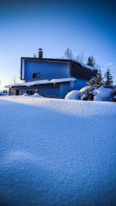 上川町Yukiumi House的一座有雪盖的院子,后面有一座建筑