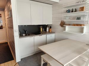 易拉斯加威Ylläs Nilimaja的厨房配有白色橱柜和桌子