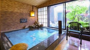 高松多美迎高松酒店的一个带窗户的房间的大型室内游泳池