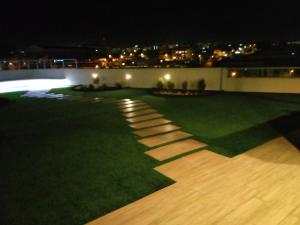 基多Departamento confortable en Quito的花园,在晚上有一条小径在草地上
