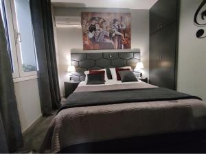 新基奥斯Music Reflections Apartment near Nafplio的卧室配有一张大床,墙上挂有绘画作品