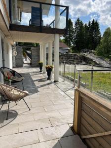 卑尔根Apartment in Åsane的一个带甲板、椅子和阳台的庭院