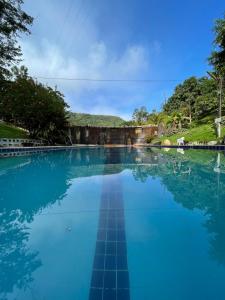 博尼托Eco Flat 314 - Hotel Fazenda Pedra do Rodeadoro的一大片蓝水,有树在背后