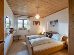 奥博奥多夫Berggasthof Bichlersee的一间卧室设有两张床和木制天花板