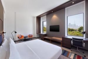 迪拜Aloft Al Mina, Dubai Jumeirah的一间酒店客房,配有一张床和一台电视