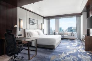 北京北京金融街威斯汀大酒店的酒店客房配有一张床、一张桌子和一把椅子。