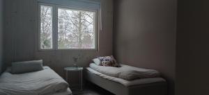 海门林纳New Villa w/sauna, jacuzzi &wifi的客房设有两张床和窗户。