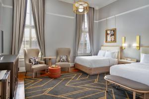 加尔维斯敦The Tremont House, Galveston, a Tribute Portfolio Hotel的酒店客房带两张床、椅子和电视