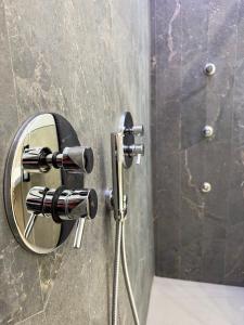 阿杰罗拉Good Vibes Luxury Rooms的浴室内淋浴墙上的镜子