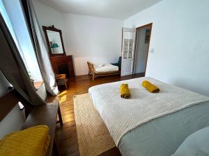 ThomeryLa Bycoque, maison au calme près de Fontainebleau的一间卧室配有一张带两个黄色枕头的床