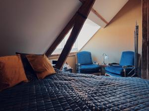 米德尔堡Boutique Hotel Bajoene的一间卧室配有一张床和两张蓝色椅子