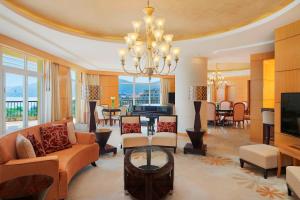 三亚三亚亚龙湾喜来登度假酒店(免税店9.5折和巴士+旅拍)的一间带吊灯的客厅和一间客厅。