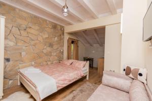 尼克希奇Ostroške grede的一间卧室设有一张床和石墙