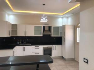赫尔格达Moubark 6 Villa 1的厨房配有白色橱柜和黑色台面