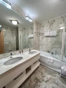 威尼斯佛斯卡里宫殿酒店的浴室设有2个水槽、浴缸和镜子