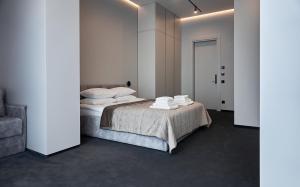 乌日霍罗德WHITE HILLS HOTEL spa&sport的一间卧室配有带毛巾的床