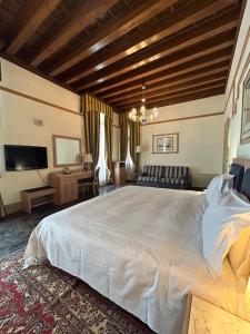 威尼斯佛斯卡里宫殿酒店的卧室配有一张白色大床和一张书桌