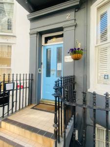 布莱顿霍夫Blue Sky Guest House的带有栅栏的房子上的一扇蓝色门
