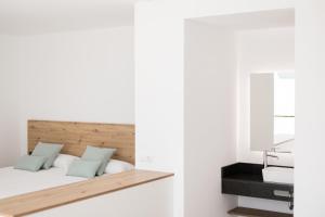 伊维萨镇Bossa Bay Suites with Private Pool - MC Apartments Ibiza的一间卧室配有一张床和镜子