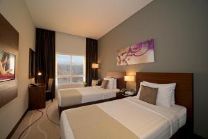 拉斯阿尔卡麦Action Hotel Ras Al Khaimah的酒店客房设有两张床和窗户。