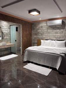 皮雷诺波利斯Pousada Raio de Luz的一间卧室设有一张大床和石墙