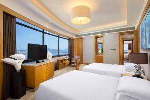 三亚三亚福朋喜来登酒店(市区海景酒店，本地美食)的酒店客房设有两张床和一台平面电视。