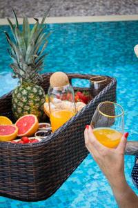 斯韦蒂·斯特凡Harmonia Bungalows & Pool的把水果和饮料篮放在游泳池里的女人