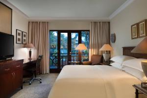 班达楠榜喜来登楠榜酒店的酒店客房配有一张床、一张书桌和一台电视。