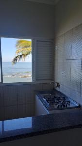 伊塔尼亚恩Hotel Pousada Miami的海景厨房(带炉灶)