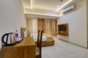 印多尔SoonStay Konark的酒店客房设有床、桌子和电视。