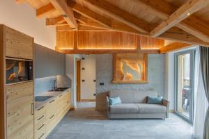 莫尔韦诺Dolomites Chalet Wolf的带沙发和木制天花板的客厅