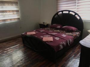 Aş ŞāfīSafi Kitchen Hostel的一间卧室配有黑色床和红色枕头