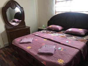 Aş ŞāfīSafi Kitchen Hostel的一间卧室配有一张带镜子和枕头的床