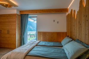 莫尔韦诺Dolomites Chalet Wolf的一间卧室设有一张大床和大窗户