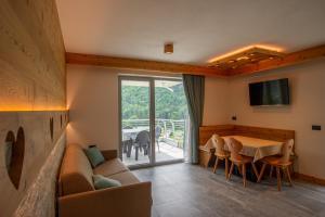 莫尔韦诺Dolomites Chalet Wolf的客厅配有沙发和桌椅