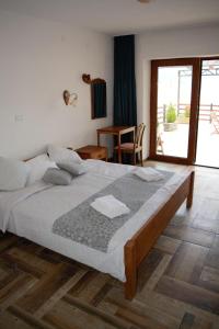 奥赫里德Villa Scandik Ohrid的一间卧室设有一张大床和一个大窗户