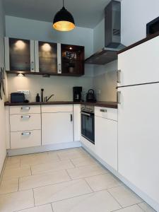 诺德霍恩FeWo Am Ring - mit Terrasse的厨房配有白色橱柜和冰箱。