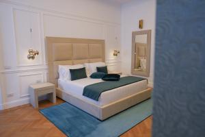罗马Màs Boutique Hotel Rome的一间卧室配有一张大床和镜子