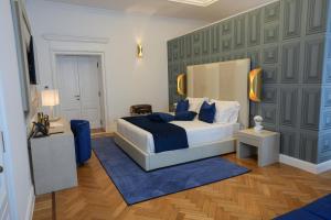 罗马Màs Boutique Hotel Rome的一间卧室配有一张特大号床和蓝色地毯。