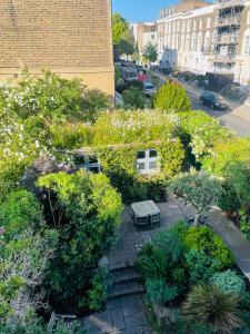 伦敦卡姆登镇花园小屋旅馆的享有带长凳和鲜花的花园美景