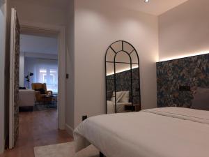希洪Apartamento Nordeste的卧室配有白色的床和镜子